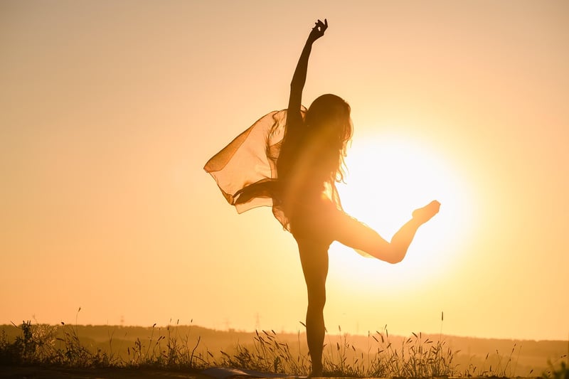 Silhouette of a woman practicing yoga at sunset